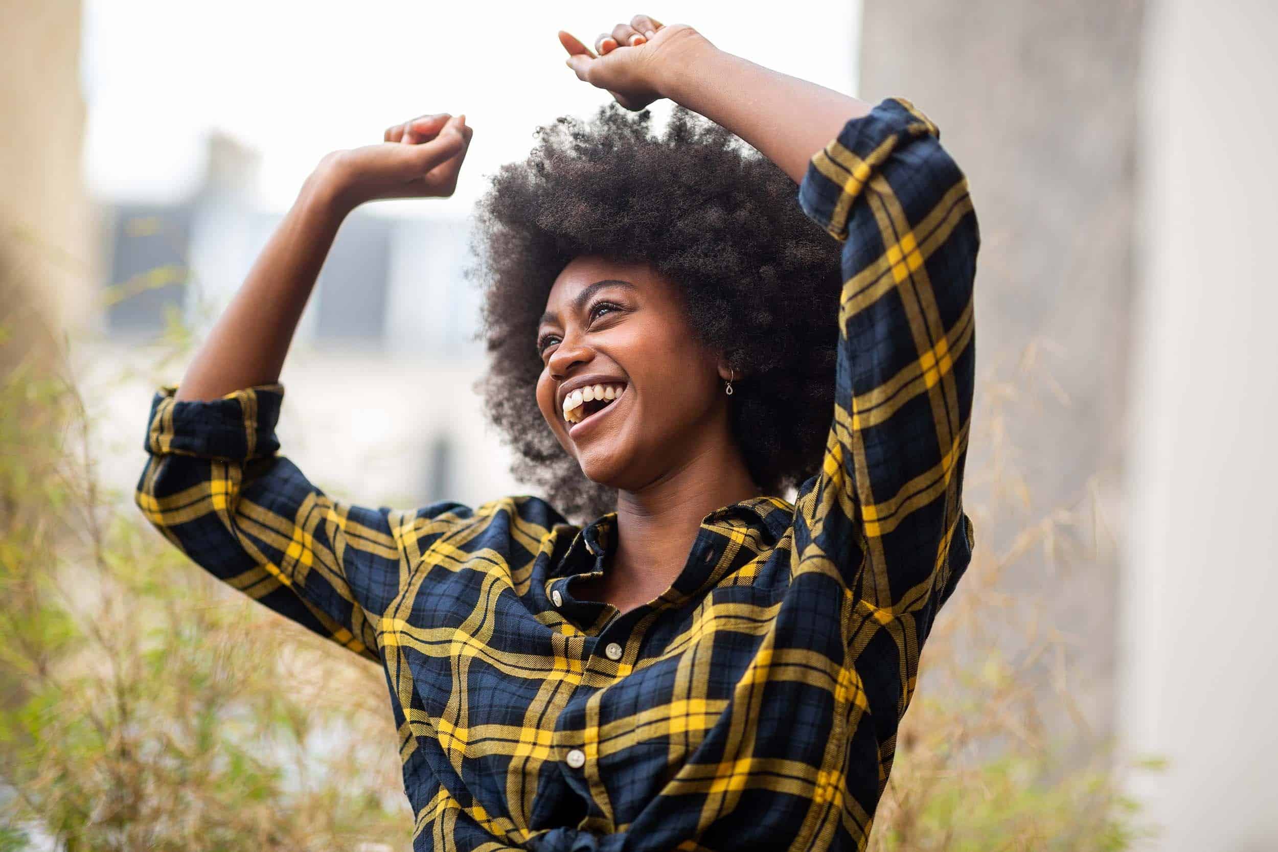 Cheerful and carefree woman dancing on the street