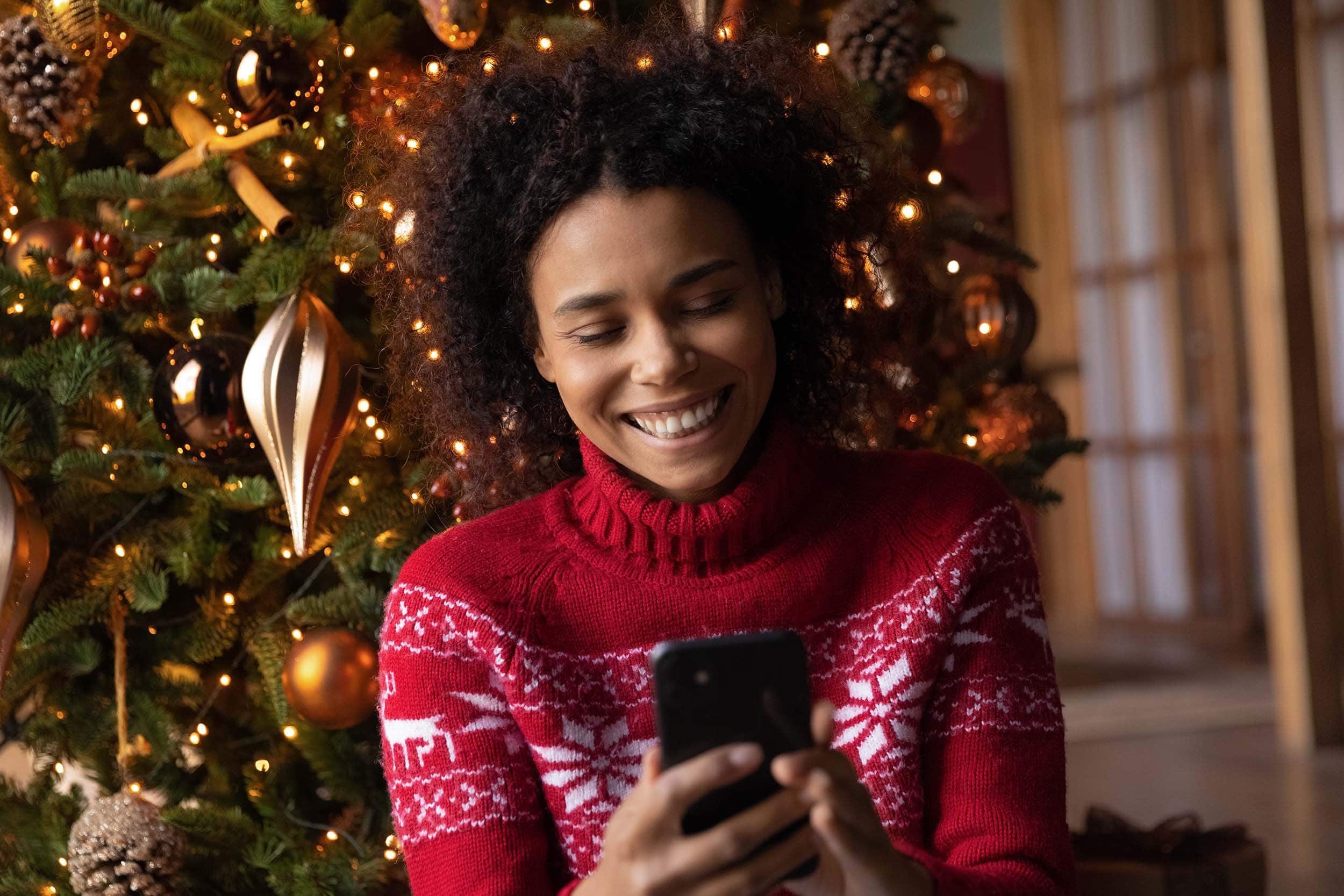 woman beaming after reading a message on christmas day