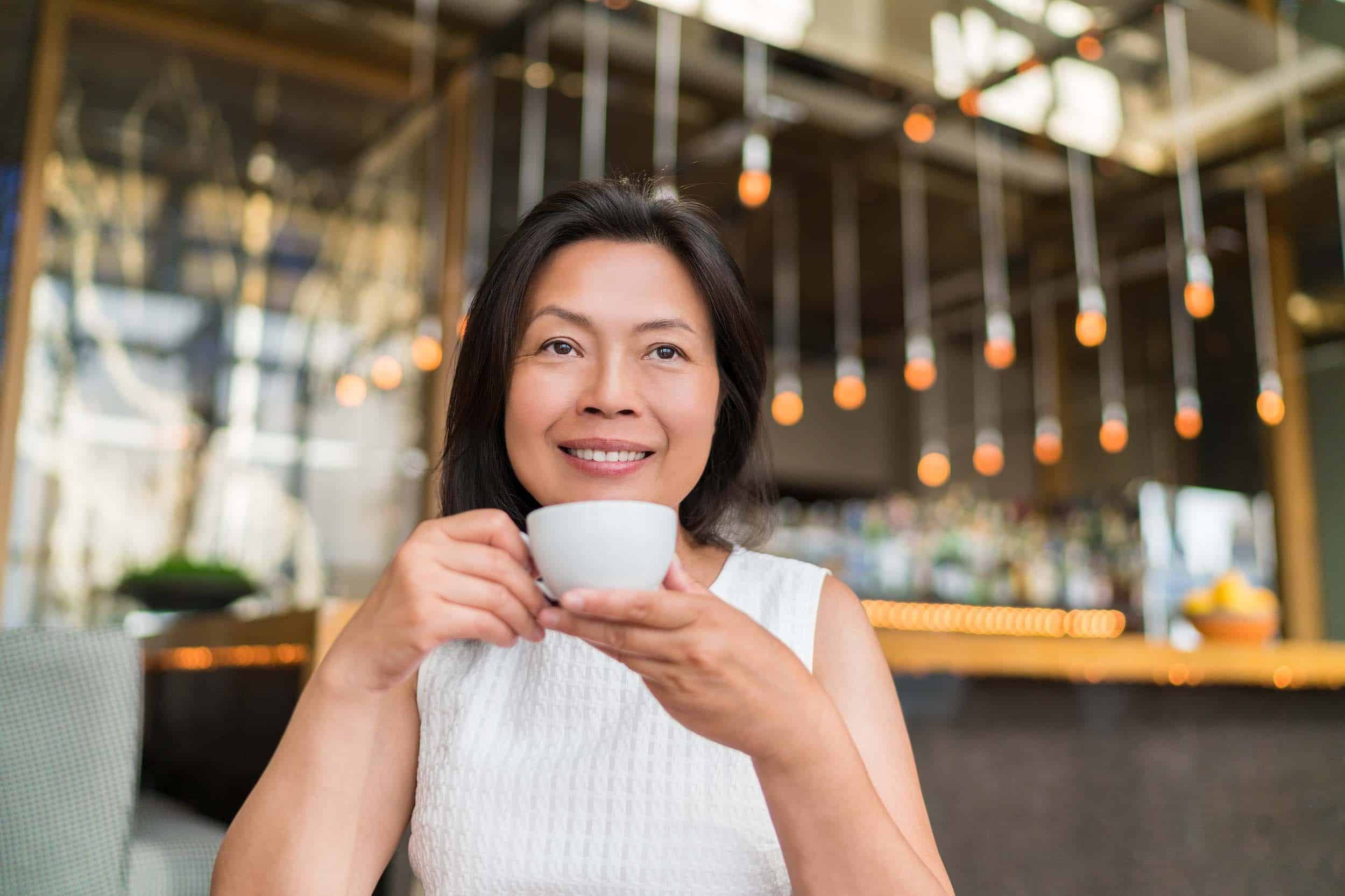 woman drinking coffee while looking content in life
