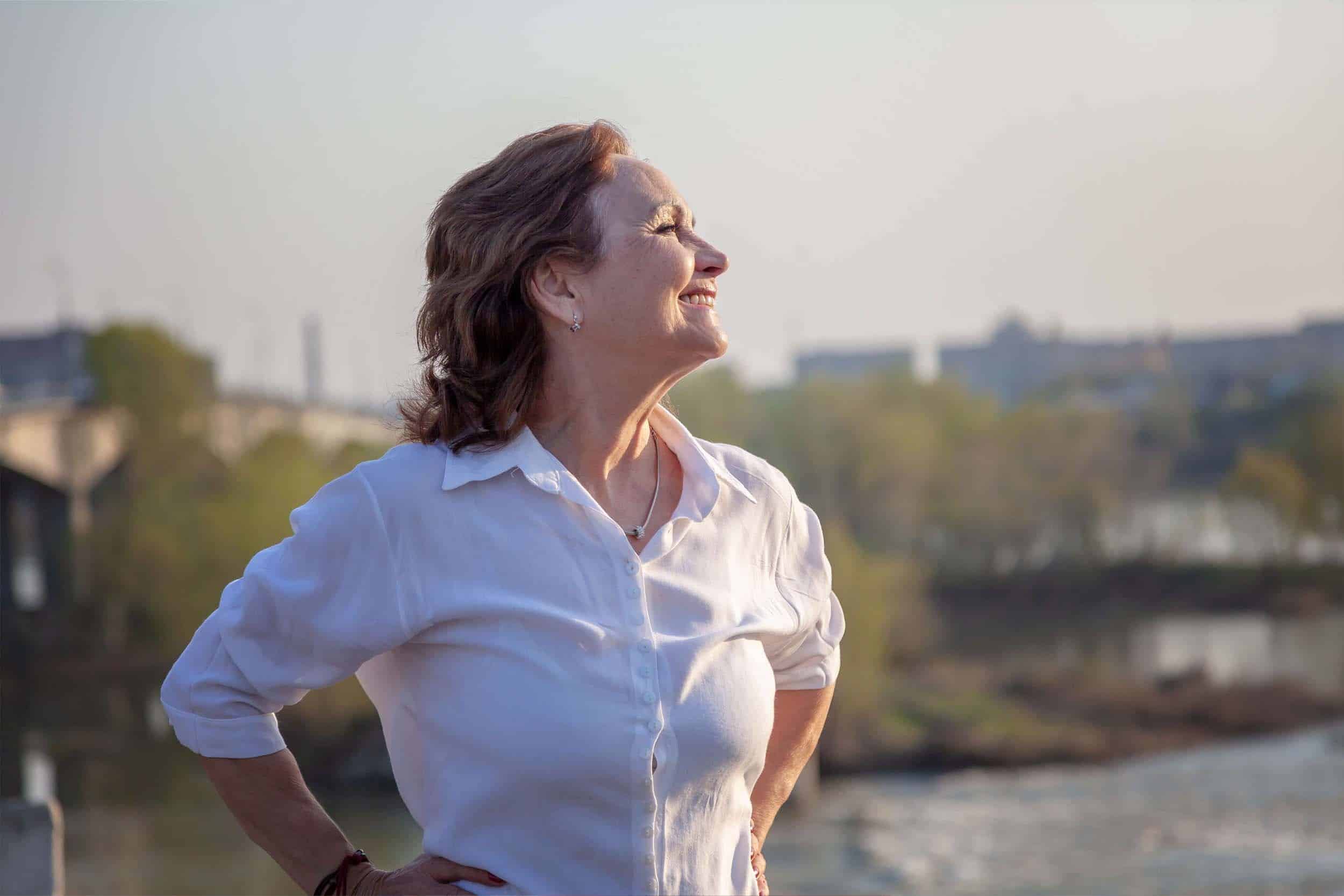 woman around 60 years old happy while enjoying the nature