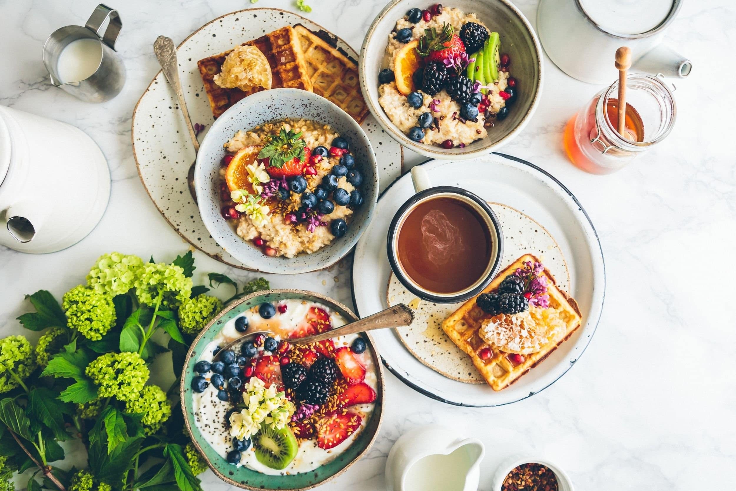 table full of waffles, chocolate drink oatmeal honey and milk