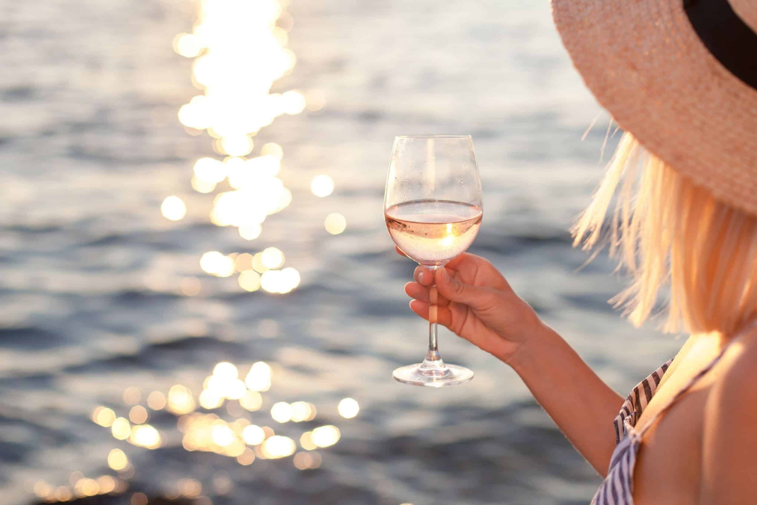 woman enjoying her cocktail drink near the sea