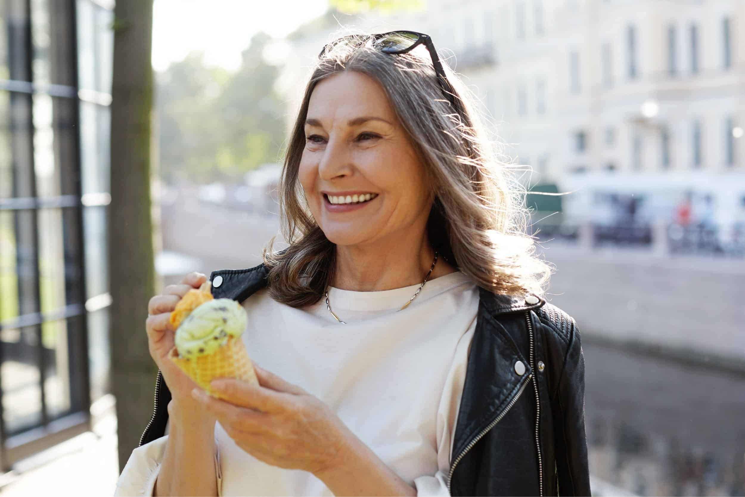 woman in her 50s happily eating her ice cream