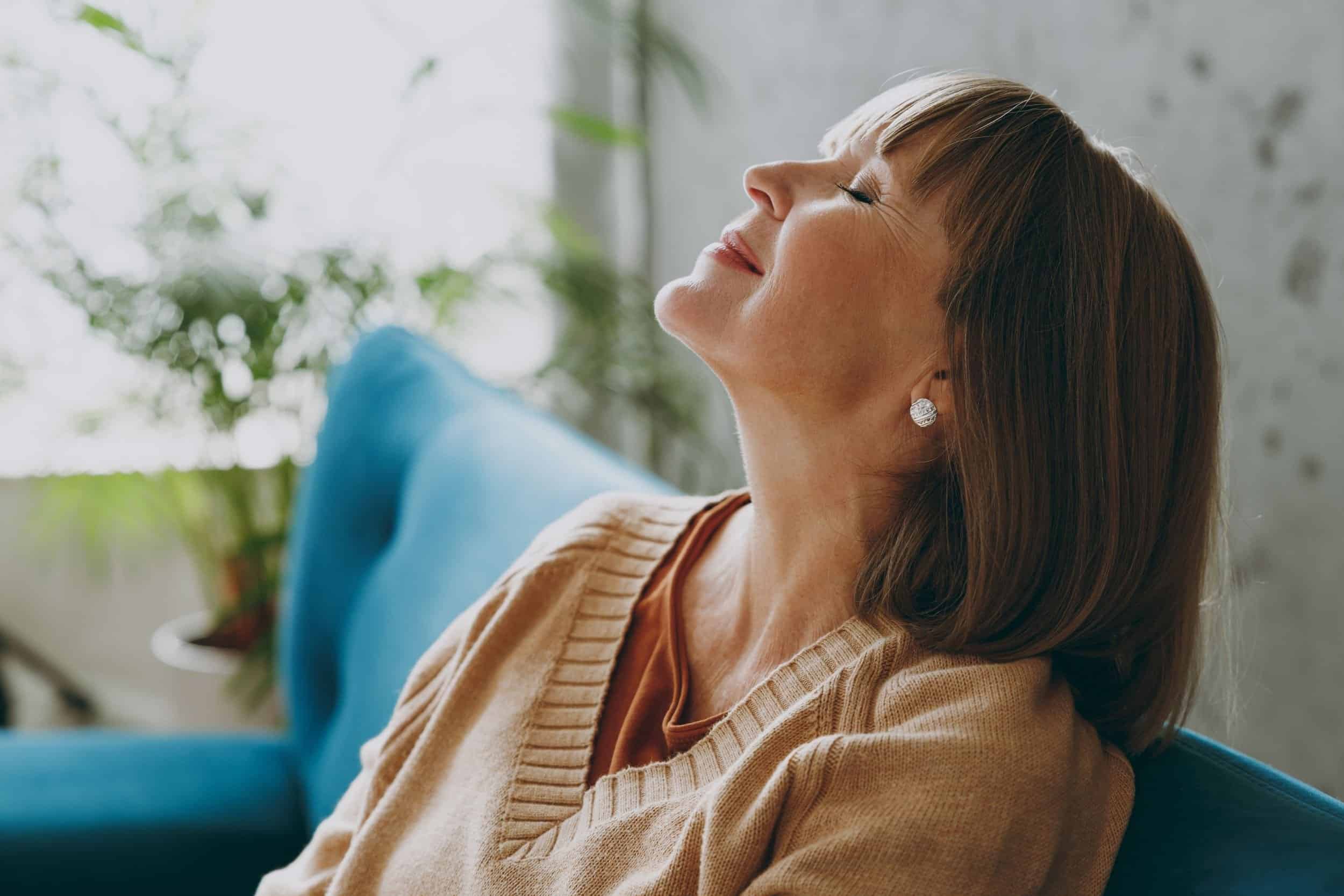 woman in her 40s smiling knowing there is peace and calmness in her life