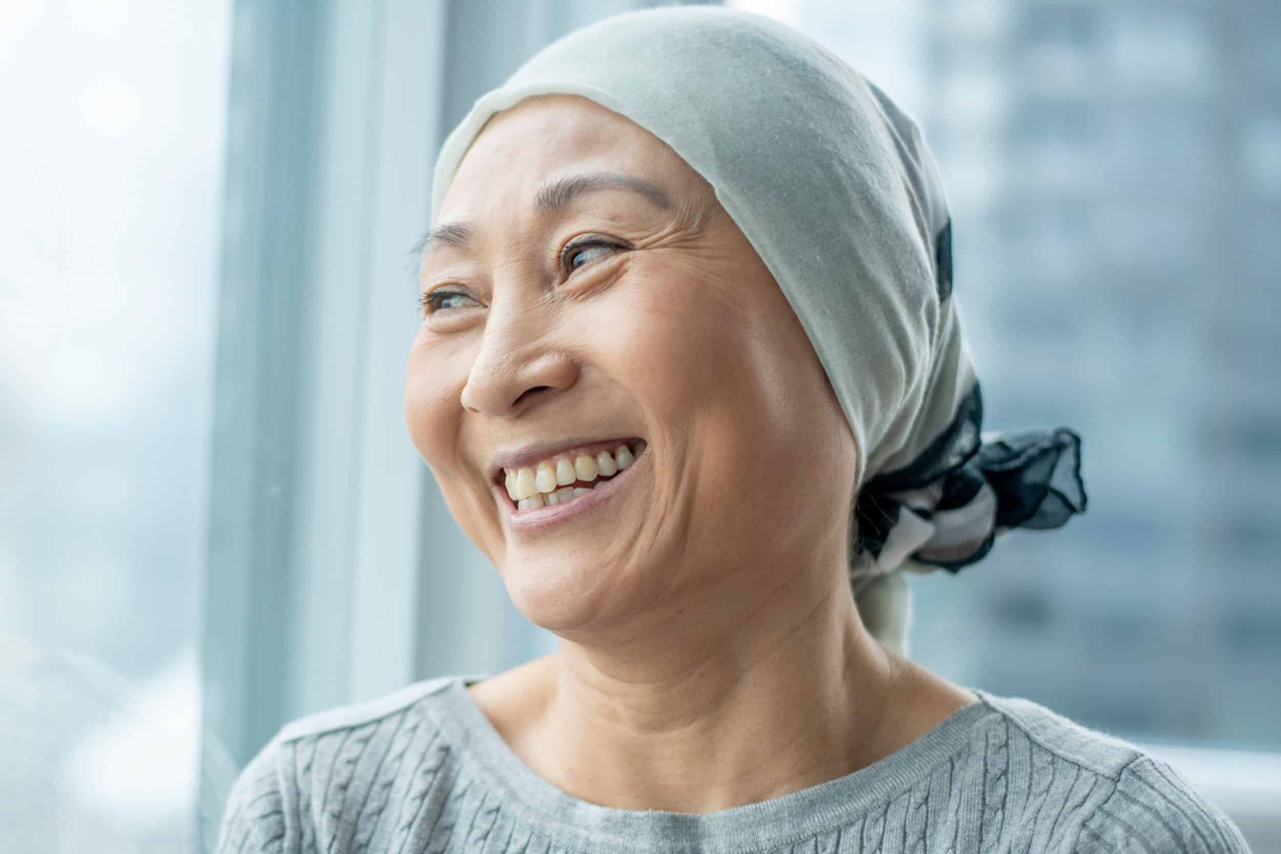 woman in her 40s smiling brightly while looking in the window